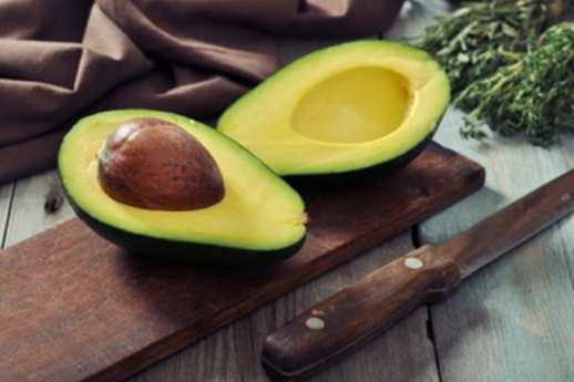 avacado-with-seed-cut-open-on-wooden-board