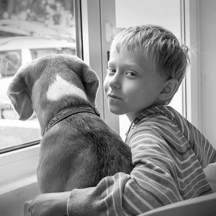 boy-and-his-dog-looking-out-of-window-black-white