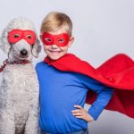 Handsome little superman with dog. Superhero. Royal Poodle