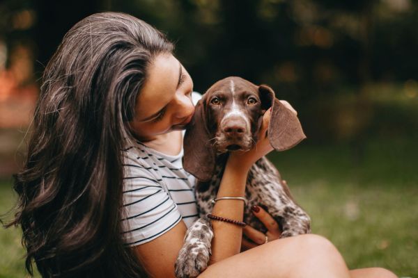 Woman cuddling a German Wirehaired Pointer puppy