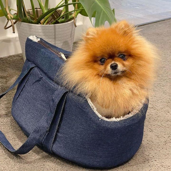 DoggyTopia denim dog carrier holding Pomeranian toy dog